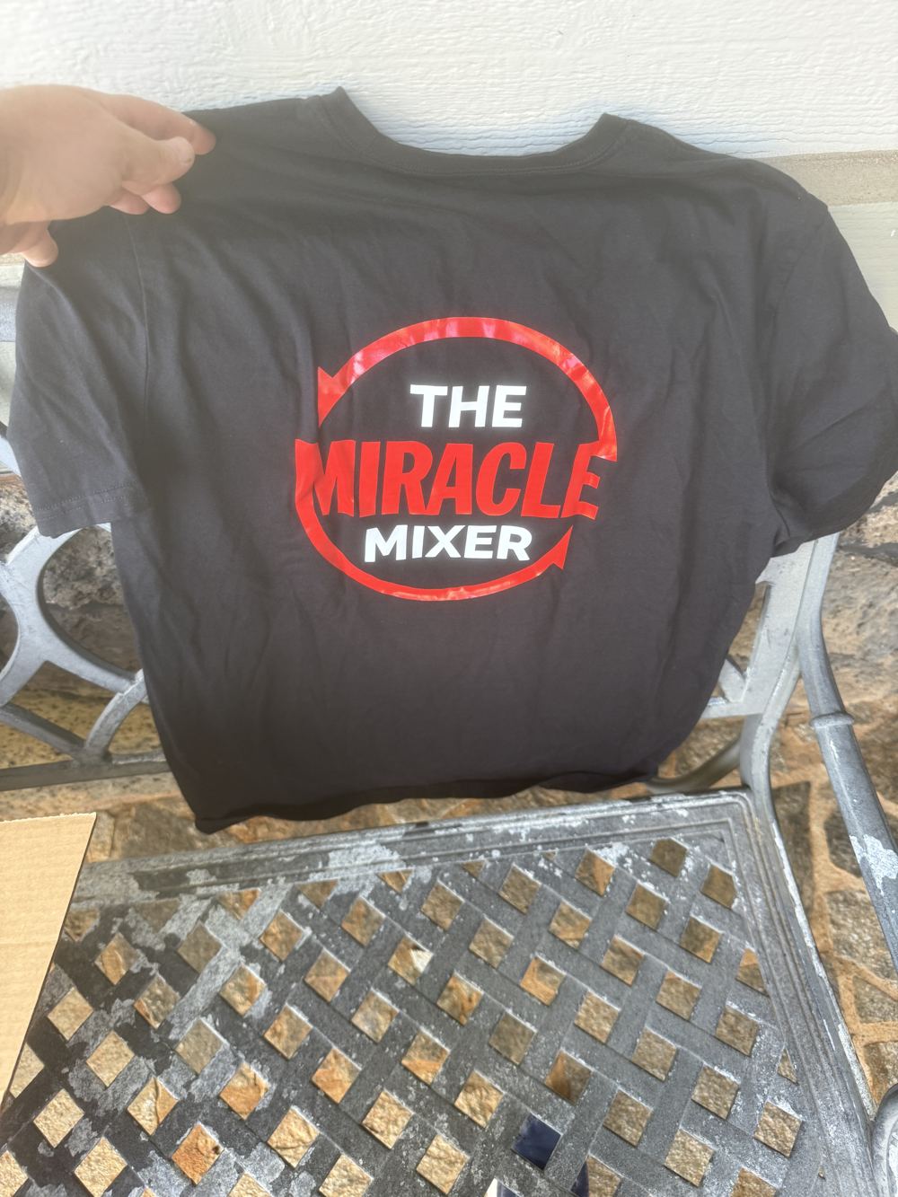 The real Miracle Mixer logo tee, held up
